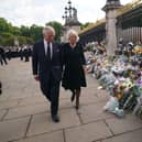 King Charles III and the Queen view tributes left outside Buckingham Palace, London, following the death of Queen Elizabeth II on Thursday. Picture date: Friday September 9, 2022.