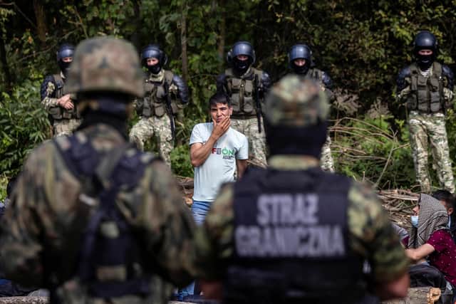 A member of a group of migrants believed to be from Afghanistan, trapped between Polish soldiers and armed police from Belarus, asks for international protection in Poland (Picture: Wojtek Rawwanski/AFP via Getty Images)