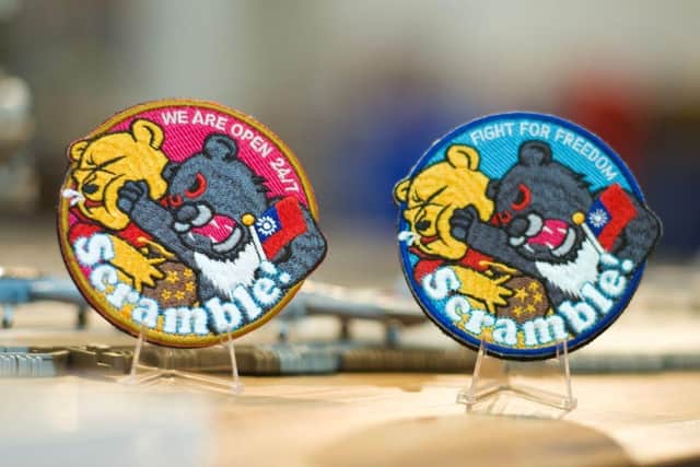 Badges depicting a Formosan black bear holding a Taiwanese flag punching Winnie-the-Pooh are on display at a shop in Taoyuan, Taiwan. China, which claims Taiwan as part of its territory, launched three days of war games on 8 April that involved simulating attacks on the democratic island in response to President Tsai Ing-wen's meeting with US House Speaker Kevin McCarthy. The iron-on patches being worn by some of Taiwan's air force pilots are a defiant message to Chinese leader Xi Jinping, often satirised for looking like Winnie the Pooh.