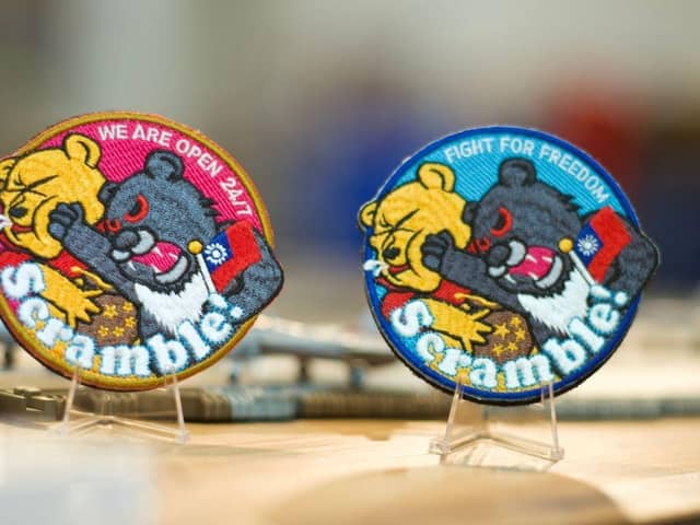 Badges depicting a Formosan black bear holding a Taiwanese flag punching Winnie-the-Pooh are on display at a shop in Taoyuan, Taiwan. China, which claims Taiwan as part of its territory, launched three days of war games on 8 April that involved simulating attacks on the democratic island in response to President Tsai Ing-wen's meeting with US House Speaker Kevin McCarthy. The iron-on patches being worn by some of Taiwan's air force pilots are a defiant message to Chinese leader Xi Jinping, often satirised for looking like Winnie the Pooh.