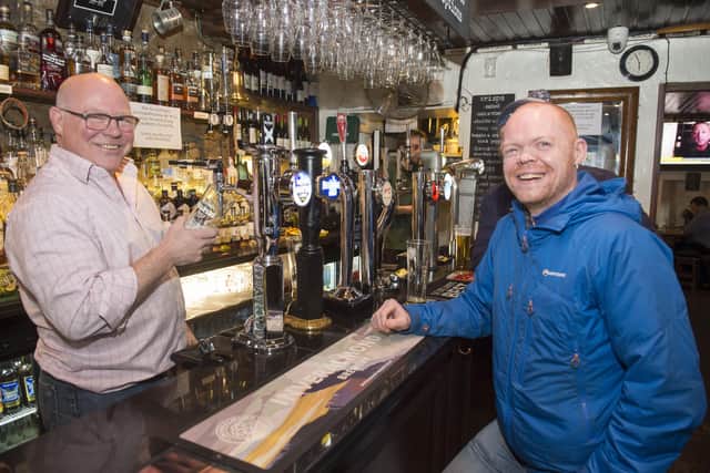 Bar owner Peter Knight pulls a last pint for customer Stuart Coyne in Teuchters Bar, Edinburgh after the government told all pubs and bars to close.