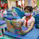 Primary school pupils wear wings to help maintain social distancing in a classroom in Taiyuan in China's northern Shanxi province. (Picture: AFP via Getty Images)