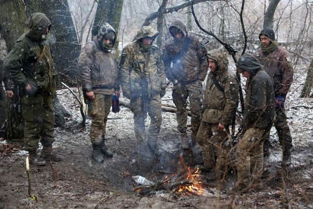 Servicemen of Ukrainian Military Forces set a fire to get warm in the Luhansk region. (Photo by Anatolii Stepanov / AFP) (Photo by ANATOLII STEPANOV/AFP via Getty Images)