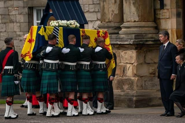 The Princess Royal curtseys the coffin of Queen Elizabeth II, draped with the Royal Standard of Scotland, as it arrives at Holyroodhouse, Edinburgh, where it will lie in rest for a day.