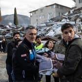 Rescue workers carry an earthquake survivor amid the ruins of collapsed buildings in Hatay, Turkey (Picture: Burak Kara/Getty Images)