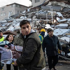 Rescue workers carry an earthquake survivor amid the ruins of collapsed buildings in Hatay, Turkey (Picture: Burak Kara/Getty Images)