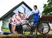 Philippa York, who previously competed as Robert Millar, beside the mural in Lennoxtown which celebrates the cyclist's achievements at the first Briton to be crowned 'King of the Mountains' in the Tour de France. Picture: John Devlin