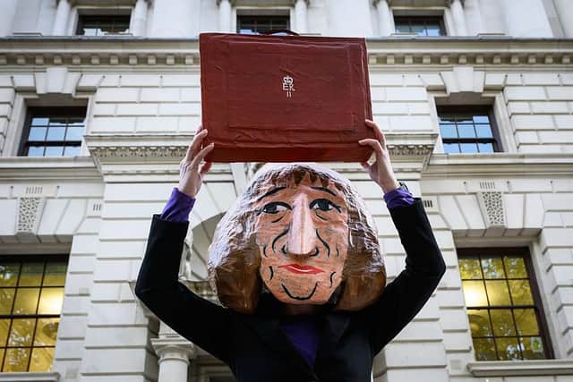A woman wears a mask of Chancellor Rachel Reeves outside the Treasury this week (Picture: Leon Neal/Getty Images)