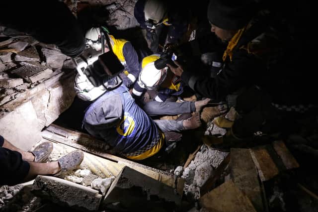 Syrian rescuers (White Helmets) retrieve an injured man from the rubble of a collapsed building  following an earthquake, in the border town of Azaz in the rebel-held north of the Aleppo province, early on February 6, 2023, - (Photo by Bakr ALKASEM / AFP) (Photo by BAKR ALKASEM/AFP via Getty Images)