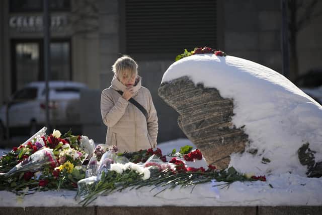 A woman reacts as she lays flowers to pay the last respect to Alexei Navalny at the monument, a large boulder from the Solovetsky islands, where the first camp of the Gulag political prison system was established, in Moscow. Picture: AP Photo/Alexander Zemlianichenko