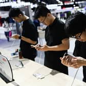Visitors test Moto smartphones at the Mobile World Congress (MWC) in Shanghai in June.