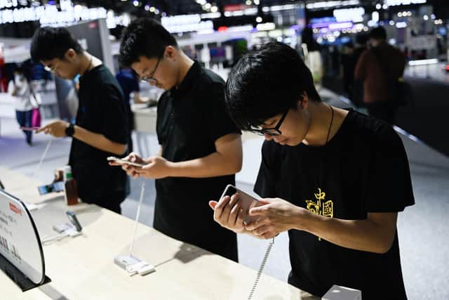 Visitors test Moto smartphones at the Mobile World Congress (MWC) in Shanghai in June.