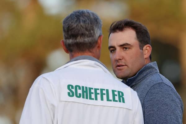 Scottie Scheffler talks with caddie Ted Scott on the 18th green during the third round of the Masters at Augusta National Golf Club. Picture: Jamie Squire/Getty Images.