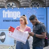 A couple check their map and phone by the street performance area on Edinburgh's Royal Mile. Picture: Jane Barlow/PA Wire