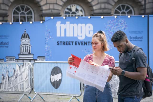 A couple check their map and phone by the street performance area on Edinburgh's Royal Mile. Picture: Jane Barlow/PA Wire