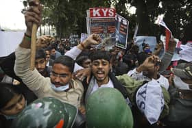 Security officers push back people shouting slogans during a protest held in support to farmers who have been on a months-long protest, in New Delhi, India. The Sikh Council UK has asked Foreign Secretary Dominic Raab to intervene.