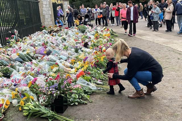 Amanda Bartlett with her daughter Ayla, lay flowers at Cambridge Gate, Long Walk, Windsor, following the death of Queen Elizabeth II on Thursday. Picture date: Friday September 9, 2022.