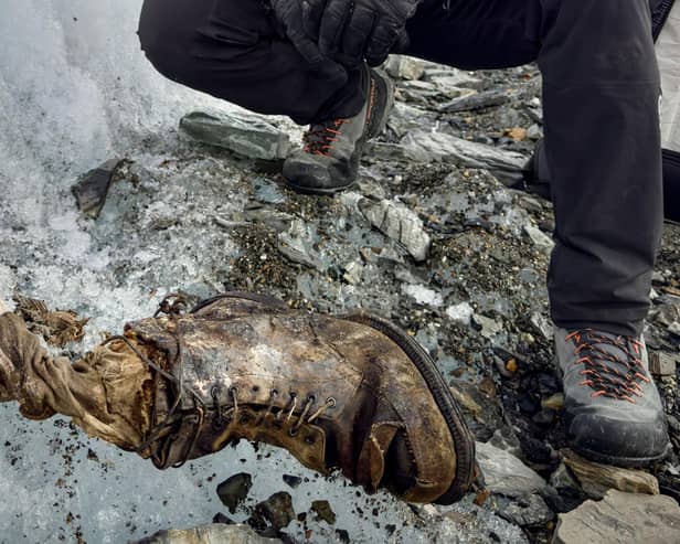 Photographer and professional climber Jimmy Chin, with a sock embroidered with "A.C. Irvine", along with a boot, which has been discovered on the Central Rongbuk Glacier below the North Face of Mount Everest. Picture: Jimmy Chin/National Geographic/PA Wire
