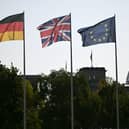 A German, Union Jack and an EU flag in the courtyard of the Chancellory with the cupola of the Reichstag building that hosts the German Parliament in the background. PIC: Justin Tallis/PA Wire