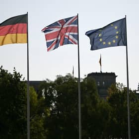A German, Union Jack and an EU flag in the courtyard of the Chancellory with the cupola of the Reichstag building that hosts the German Parliament in the background. PIC: Justin Tallis/PA Wire