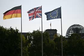 A German, Union Jack and an EU flag in the courtyard of the Chancellory with the cupola of the Reichstag building that hosts the German Parliament in the background. PIC: Justin Tallis/PA Wire