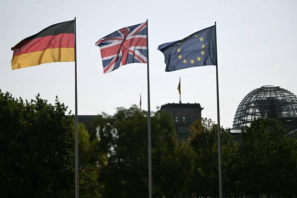 A German, Union Jack and an EU flag in the courtyard of the Chancellory with the cupola of the Reichstag building that hosts the German Parliament in the background. PIC: Justin Tallis/PA Wire