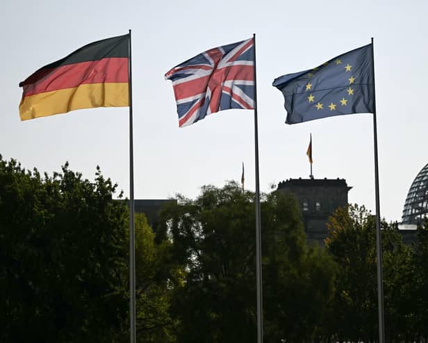 A German, Union Jack and an EU flag in the courtyard of the Chancellory with the cupola of the Reichstag building that hosts the German Parliament in the background. PIC: Justin Tallis/PA Wire