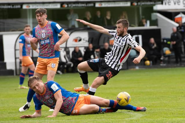 Queen's Park defender Peter Grant slides into a challenge on Dunfermline's Liam Polwarth during the Championship play-off semi-final second leg at East End Park. (Photo by Sammy Turner / SNS Group)