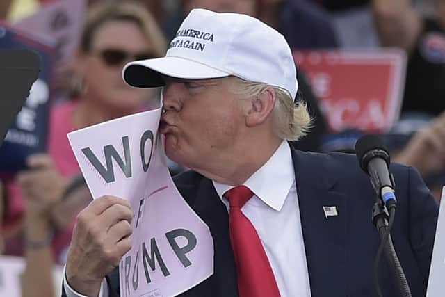 Donald Trump kisses a 'Women for Trump' placard during a rally ahead of this 2016 US presidential election win (Picture: Mandel Ngan/AFP via Getty Images)