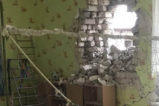 A damaged wall after the reported shelling of a kindergarten in the settlement of Stanytsia Luhanska, Ukraine  on Thursday.
(Ukrainian Presidential Press Office via AP)
