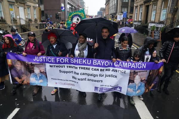 The sister of Sheku Bayoh, Kadi Johnston (centre) and Human rights lawyer Aamer Anwar (centre right) during a anti-racism and anti-fascist march in Glasgow. The inquiry into the death of a man who was restrained by police will hear from his family for the first time as hearings resume on Tuesday.