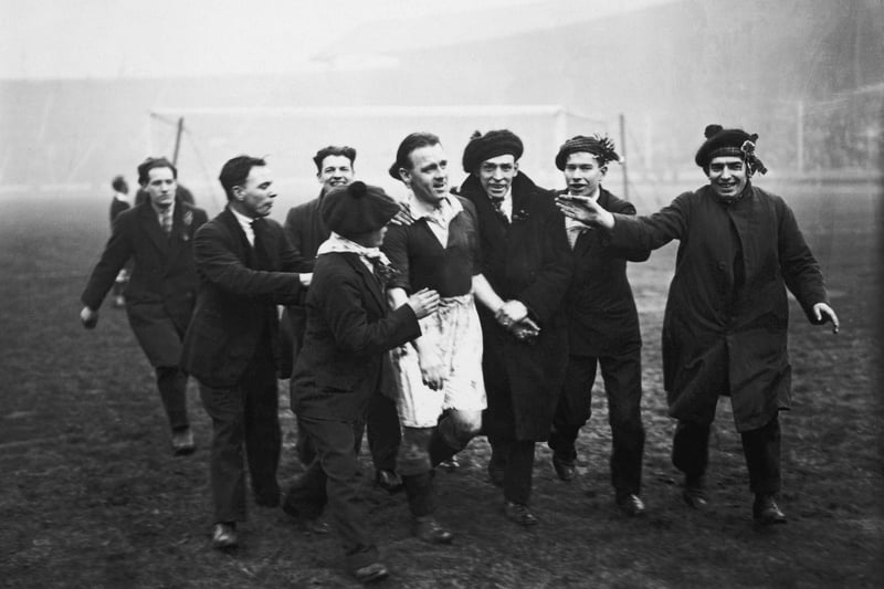 Scotland fans escorting captain Jimmy McMullan from the pitch at Wembley after Scotland had beaten England 5-1.