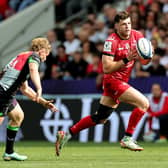 Blair Kinghorn of Toulouse gets away from Louis Lynagh during the victory over Harlequins.