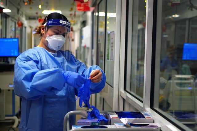A nurse puts on PPE in a ward