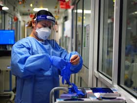 A nurse puts on PPE in a ward
