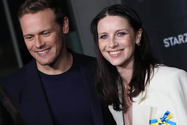 Caitriona Balfe wears a ribbon in support of Ukraine with Sam Heughan at the Season 6 premiere of Outlander in Hollywood (Photo by David Livingston/Getty Images)