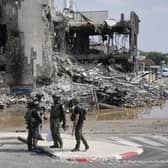 Israeli police retrieve weapons used by militants outside a police station that was overrun by Hamas gunmen on Saturday, in Sderot, Israel (AP Photo/Ohad Zwigenberg)