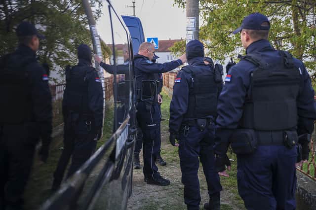 Police officers prepare for a chase in the village of Dubona, some 30 miles south of Belgrade. Picture: AP Photo/Armin Durgut