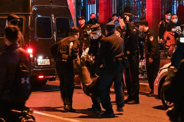 A man is arrested while people gathering on a street in Shanghai on November 27, 2022, where protests against China's zero-Covid policy took place the night before following a deadly fire in Urumqi, the capital of the Xinjiang region. (Photo by Hector RETAMAL / AFP) (Photo by HECTOR RETAMAL/AFP via Getty Images)