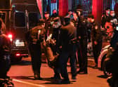 A man is arrested while people gathering on a street in Shanghai on November 27, 2022, where protests against China's zero-Covid policy took place the night before following a deadly fire in Urumqi, the capital of the Xinjiang region. (Photo by Hector RETAMAL / AFP) (Photo by HECTOR RETAMAL/AFP via Getty Images)