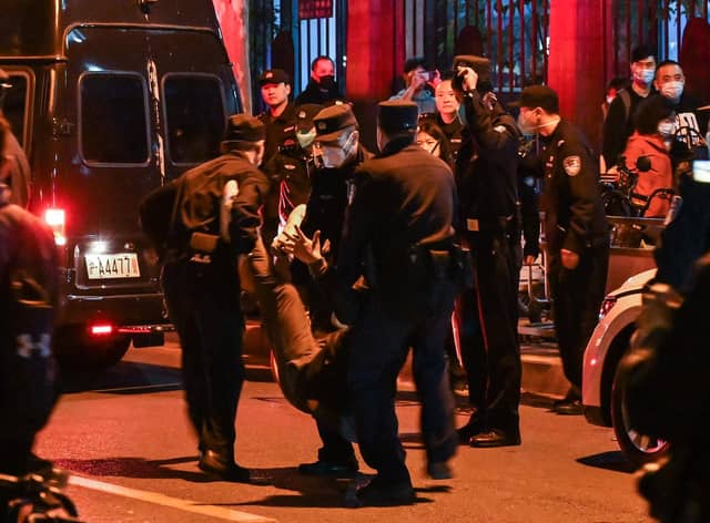 A man is arrested while people gathering on a street in Shanghai on November 27, 2022, where protests against China's zero-Covid policy took place the night before following a deadly fire in Urumqi, the capital of the Xinjiang region. (Photo by Hector RETAMAL / AFP) (Photo by HECTOR RETAMAL/AFP via Getty Images)