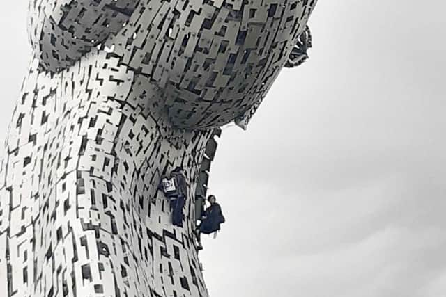 The climate activists can be seen near the top of the Andy Scott sculpture. Pic: Contributed