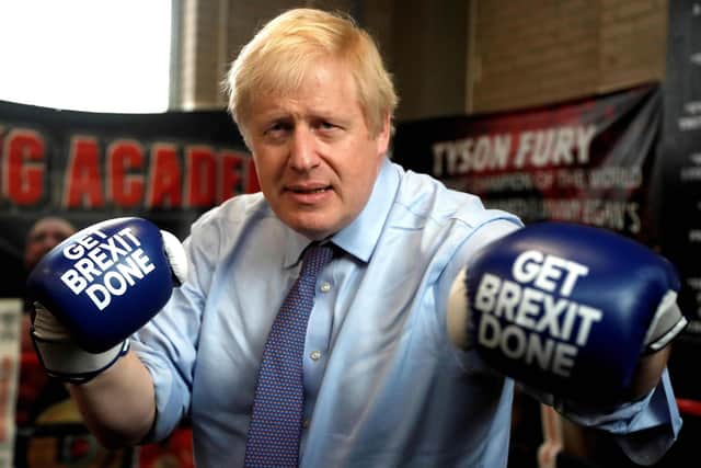 Britain's Prime Minister and leader of the Conservative Party, Boris Johnson wears boxing gloves emblazoned with "Get Brexit Done" as he poses for a photograph at Jimmy Egan's Boxing Academy in Manchester. Picture: Frank Augstein/POOL/AFP via Getty Images