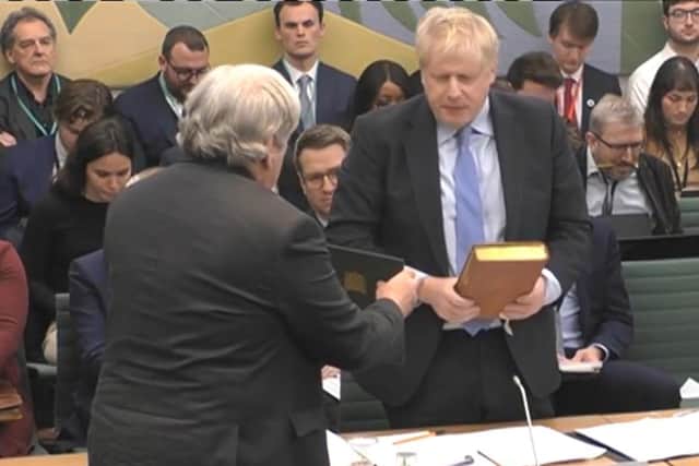 The Clerk to the Committee (left) administers the oath to former prime minister Boris Johnson ahead of his evidence to the Privileges Committee.