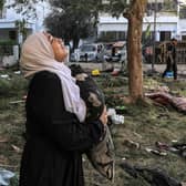 A woman reacts while holding a pillow as she stands amid debris outside the site of the Ahli Arab hospital in central Gaza in the aftermath of an overnight strike there. Photo: AFP via Getty Images