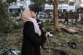 A woman reacts while holding a pillow as she stands amid debris outside the site of the Ahli Arab hospital in central Gaza in the aftermath of an overnight strike there. Photo: AFP via Getty Images