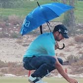 Scott Jamieson shelters under a hotel umbrella during the final round of the Commercial Bank Qatar Masters on Sunday. Picture: Josh Antmann