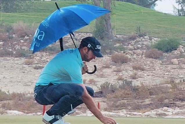 Scott Jamieson shelters under a hotel umbrella during the final round of the Commercial Bank Qatar Masters on Sunday. Picture: Josh Antmann