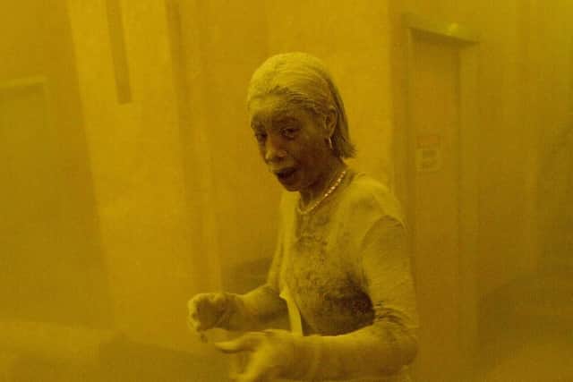This 11 September 2001 file photo shows Marcy Borders covered in dust as she takes refuge in an office building after one of the World Trade Center towers collapsed in New York. Borders was caught outside on the street as the cloud of smoke and dust enveloped the area.  The woman was caught outside on the street as the cloud of smoke and dust enveloped the area.  AFP PHOTO/Stan HONDA (Photo by STAN HONDA / AFP) (Photo by STAN HONDA/AFP via Getty Images)