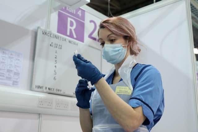 A vaccinator in Glasgow prepares a shot of Covid-19 vaccine. Photo by Andrew Milligan - WPA Pool/Getty Images
